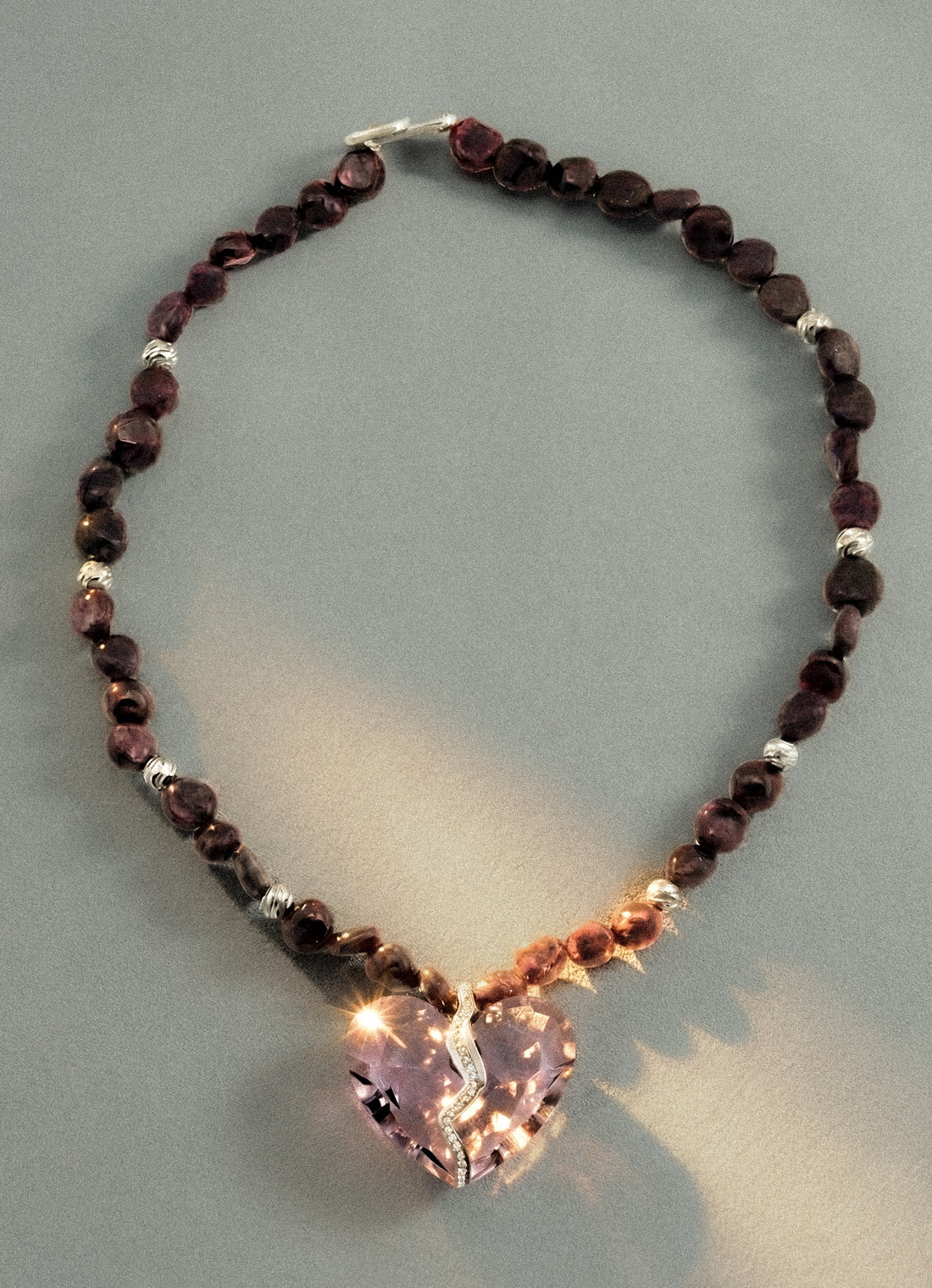 Angled view of Completed Hearts Garnet Necklace showcasing heart pendant
